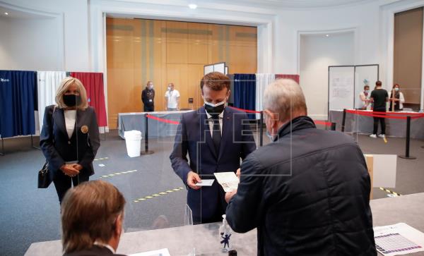 El presidente francés, Emmanuel Macron (c) junto a su esposa, en el colegio electoral de Le Touquet-Paris-Plage, en el que han depositado su voto para los comicios regionales que se celebran este domingo en Francia. EFE/EPA/CHRISTIAN HARTMANN